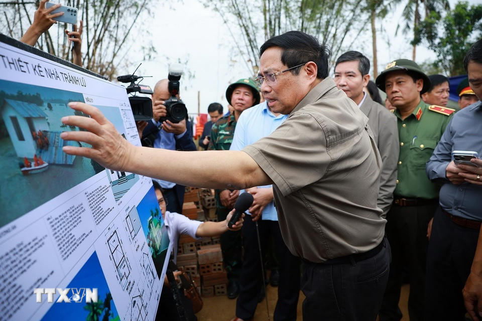 Thủ tướng Phạm Minh Chính xem phương án xây dựng nhà tránh lũ cho bà con, nhân dân vùng lũ. (Ảnh: Dương Giang/TTXVN)