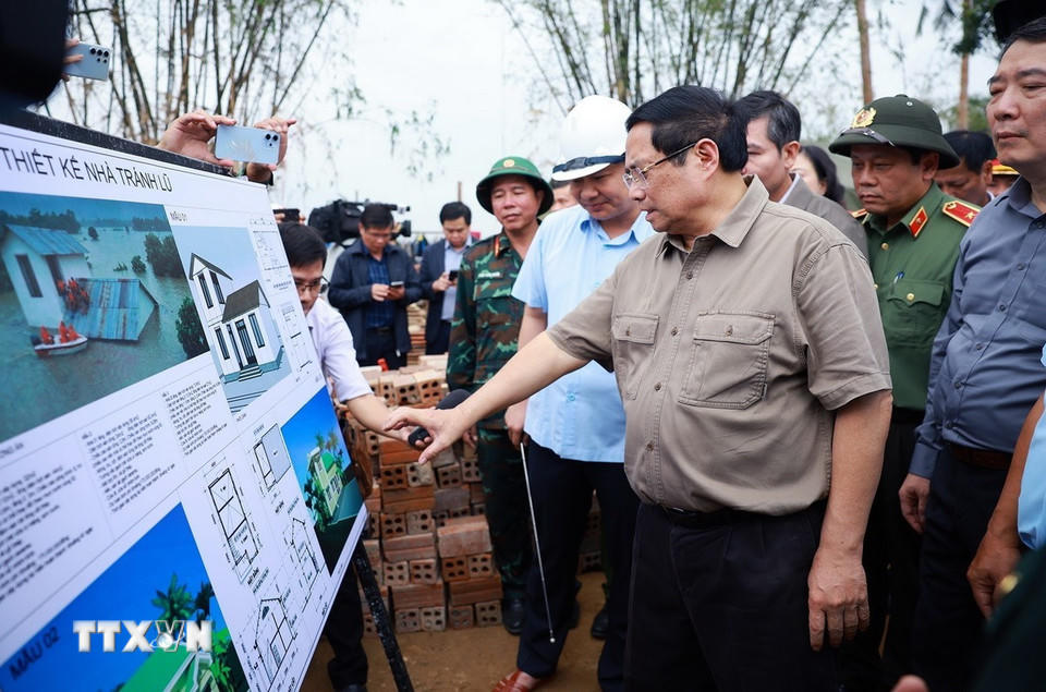 Thủ tướng Phạm Minh Chính thăm vùng ngập nước hoàn toàn tại thôn Phú Hữu, xã Hòa Thịnh và nghe báo cáo về phương án xây dựng nhà tránh lũ cho bà con, nhân dân vùng lũ. (Ảnh: Dương Giang/TTXVN)