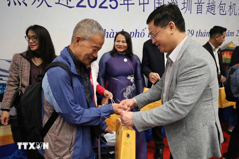 Các hành khách trên chuyến bay DZ6355 được lãnh đạo thành phố Huế trao hoa và tặng quà lưu niệm chúc mừng. (Ảnh: Văn Dũng/TTXVN).