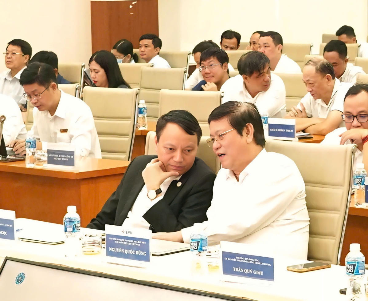 Ông Trần Quý Giầu - Trưởng ban Ban Đo lường Ủy ban Tiêu chuẩn Đo lường Chất lượng Quốc gia và ông Nguyễn Quốc Dũng - Trưởng Ban Kinh doanh mua bán điện EVN trao đổi tại Hội thảo