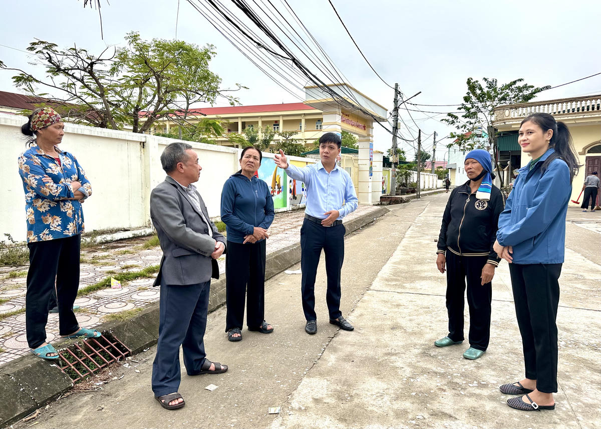 Lãnh đạo Ủy ban MTTQ Việt Nam phường Phong Cốc và bà Trần Thu Hà, Phó Bí thư Chi bộ, Trưởng Ban CTMT khu Cẩm Lũy tuyên truyền cho người dân về ý nghĩa của dự án cải tạo, nâng cấp đường Cửa Lũy. Ảnh: Ngọc Anh