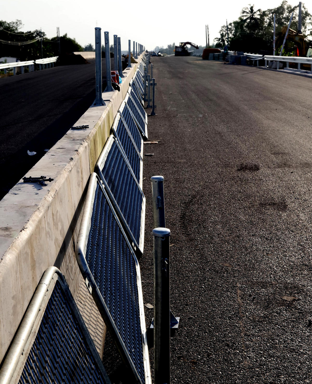 Nhiều đoạn đã hoàn thành thảm nhựa tiến hành lắp lưới chống chói. Ảnh Quốc Trung&nbsp;