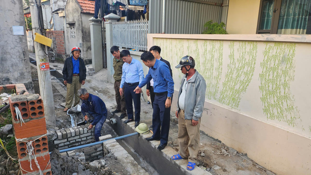 Lãnh đạo Ủy ban MTTQ Việt Nam phường Phong Cốc cùng cán bộ khu phố và nhân dân giám sát việc thi công tuyến rãnh thoát nước kết hợp cải tạo nâng cấp nền đường ngõ 13 đường nhà Mạc. Ảnh: HP