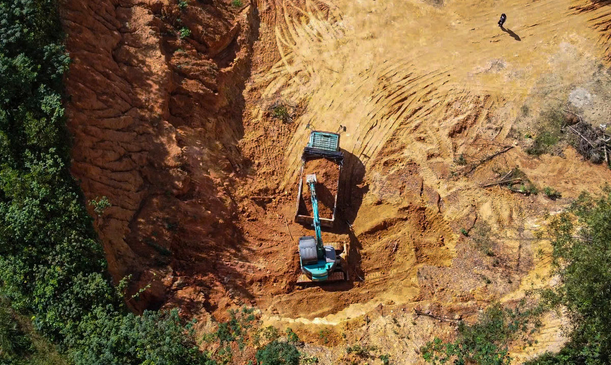 Máy xúc dạng xích cỡ vừa liên tục múc đất đưa lên thùng xe mang BKS&nbsp;38C-020.05. Ảnh: cẩm Kỳ&nbsp;