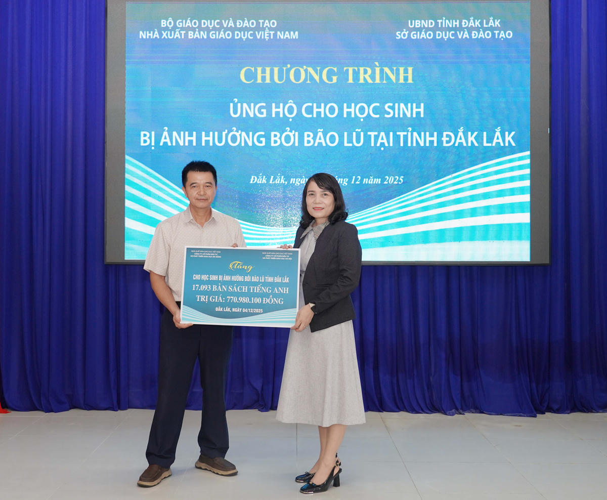 Ông Nguyễn Duy Nhâm - Phó Tổng Giám đốc Công ty CP Đầu tư và Phát triển Giáo dục Đà Nẵng trao biển tặng sách Tiếng Anh cho đại diện Sở GD-ĐT tỉnh Đắk Lắk