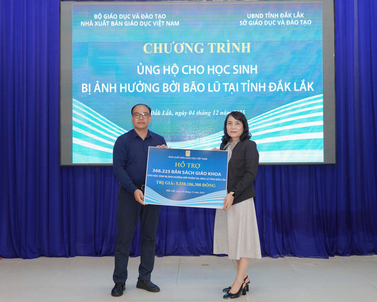 Ông Đặng Thanh Hải - Phó Tổng Giám đốc NXBGDVN trao biển tặng sách giáo khoa cho bà Võ Thị Minh Duyên - Phó Giám đốc Sở GD-ĐT tỉnh Đắk Lắk.