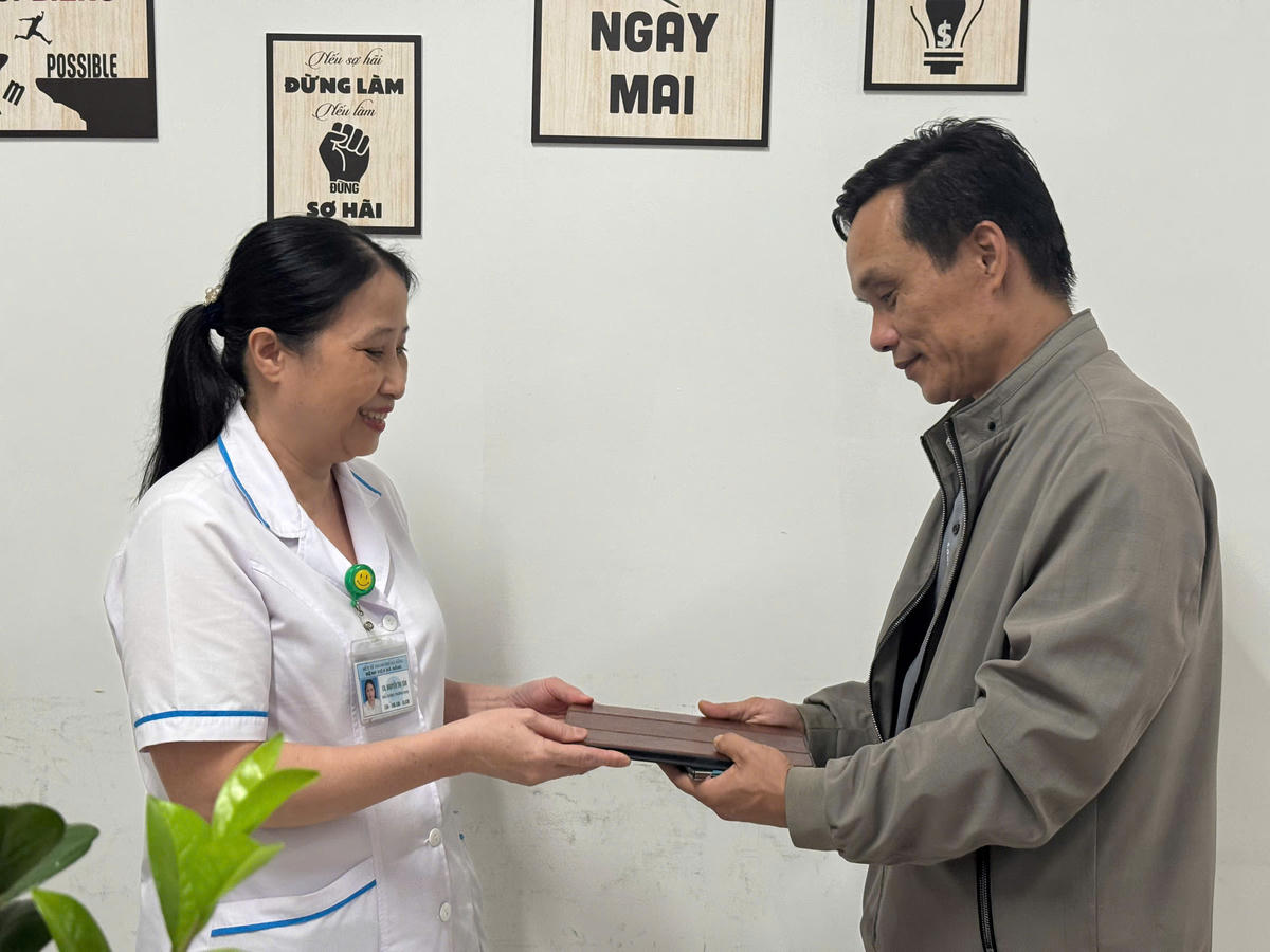 Chị Nguyễn Thị Tân bàn giao iPad cho ông Nguyễn Khoa Quyền. Ảnh: Nguyễn Tú.