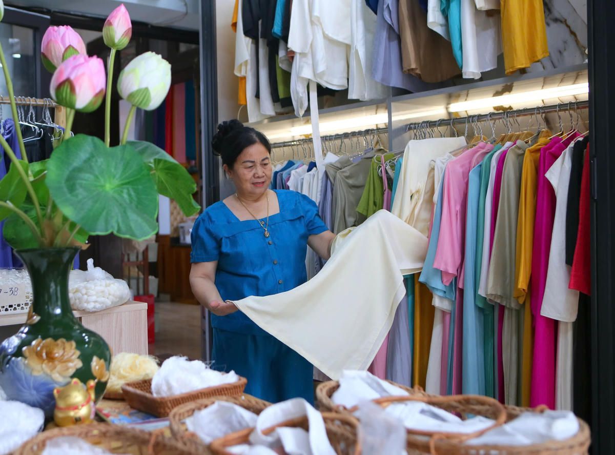 Bà Trần Thị Ngọc với những sản phẩm tơ lụa do mình tự cắt may. Ảnh: Duy Hưng.