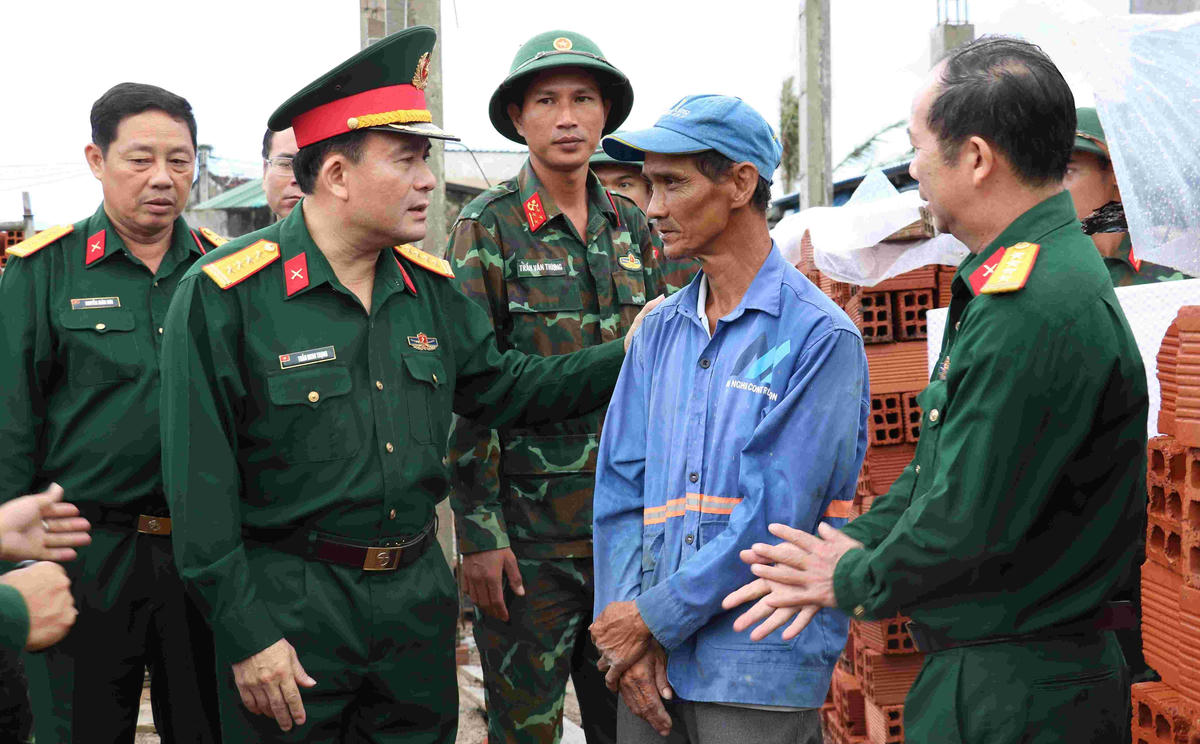 Lãnh đạo Quân khu 5 thăm hỏi ông Lê Văn Mười có nhà bị hư hỏng vì thiên tai. Ảnh: CV. 