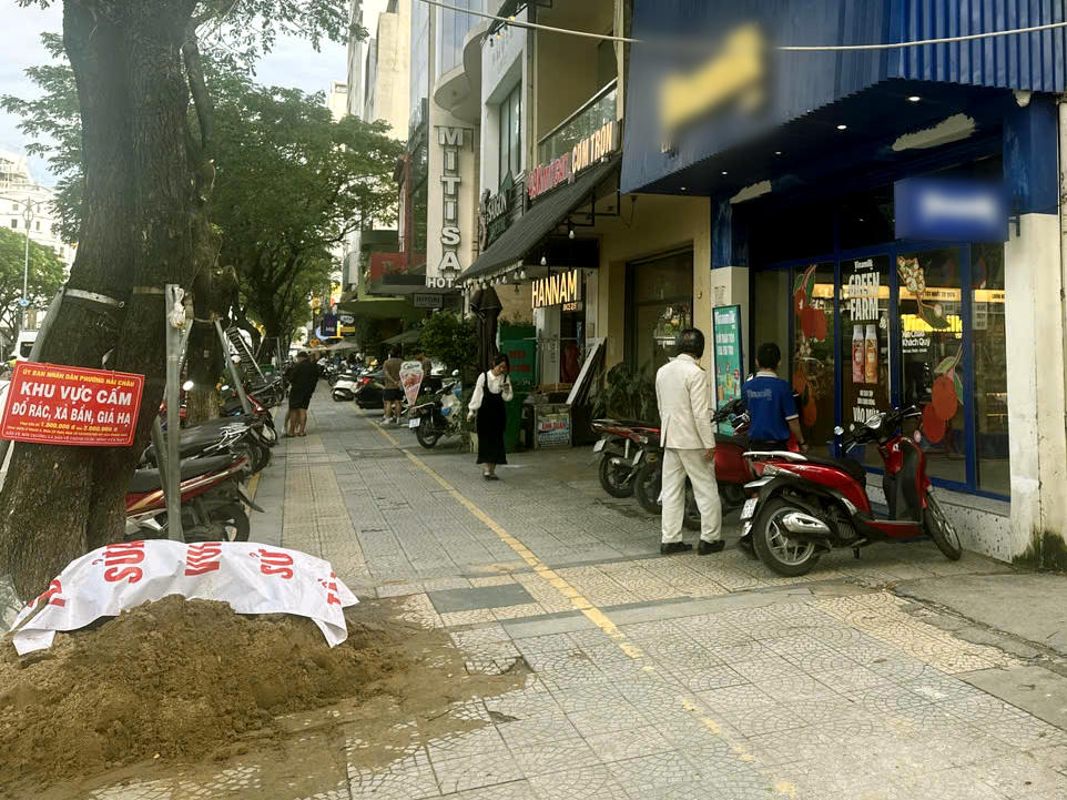 Lực lượng địa phương xử lý một điểm tập kết vật liệu xây dựng trên đường Nguyễn Văn Linh. Ảnh: Nguyễn Tú.