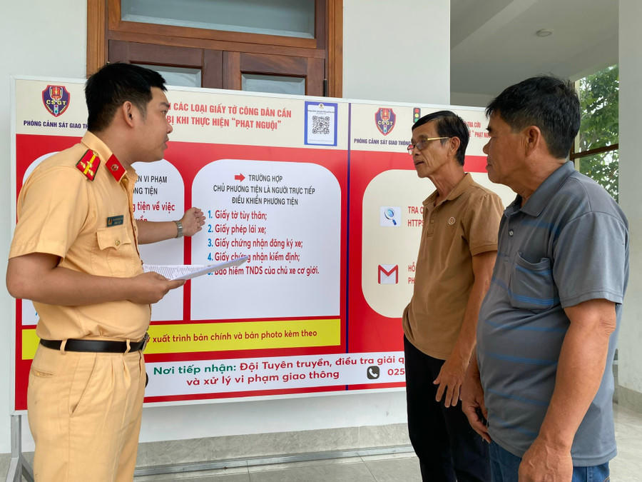 Cán bộ Phòng CSGT, Công an tỉnh Gia Lai hướng dẫn người dân một số nội dung liên quan đến thủ tục nộp phạt nguội. Ảnh: CV.