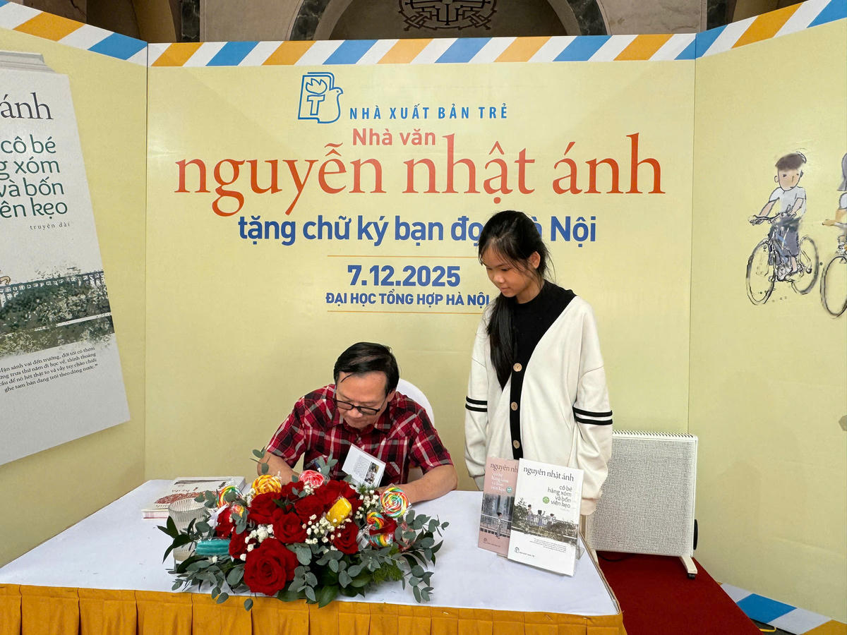 Nhà văn Nguyễn Nhật Ánh tặng chữ ký bạn đọc Hà Nội, sáng 7/12. Ảnh: Thư Hoàng.
