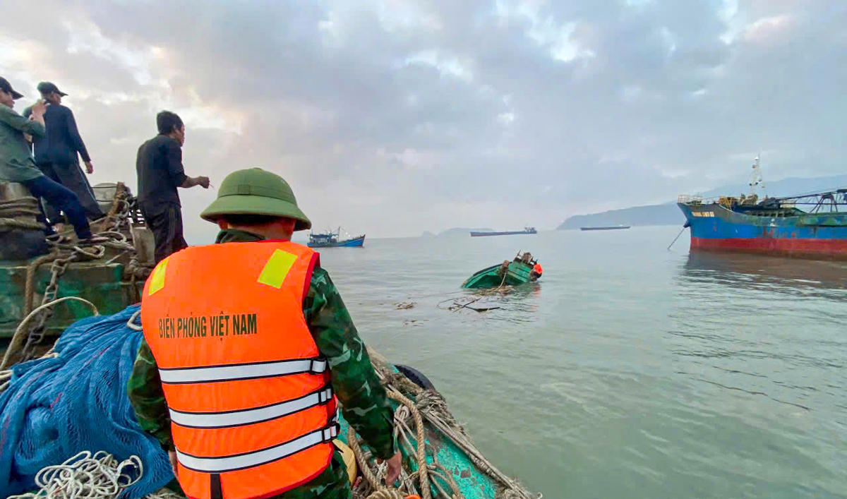 Cán bộ Trạm Biên phòng cửa khẩu Cảng Hòn La tiếp cận tàu cá bị chìm. Ảnh: HN