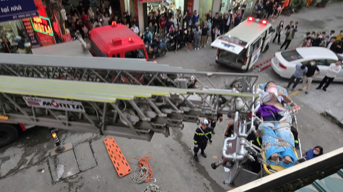 Lực lượng chức năng dùng thang giải cứu cháu bé bị rơi từ tầng cao.