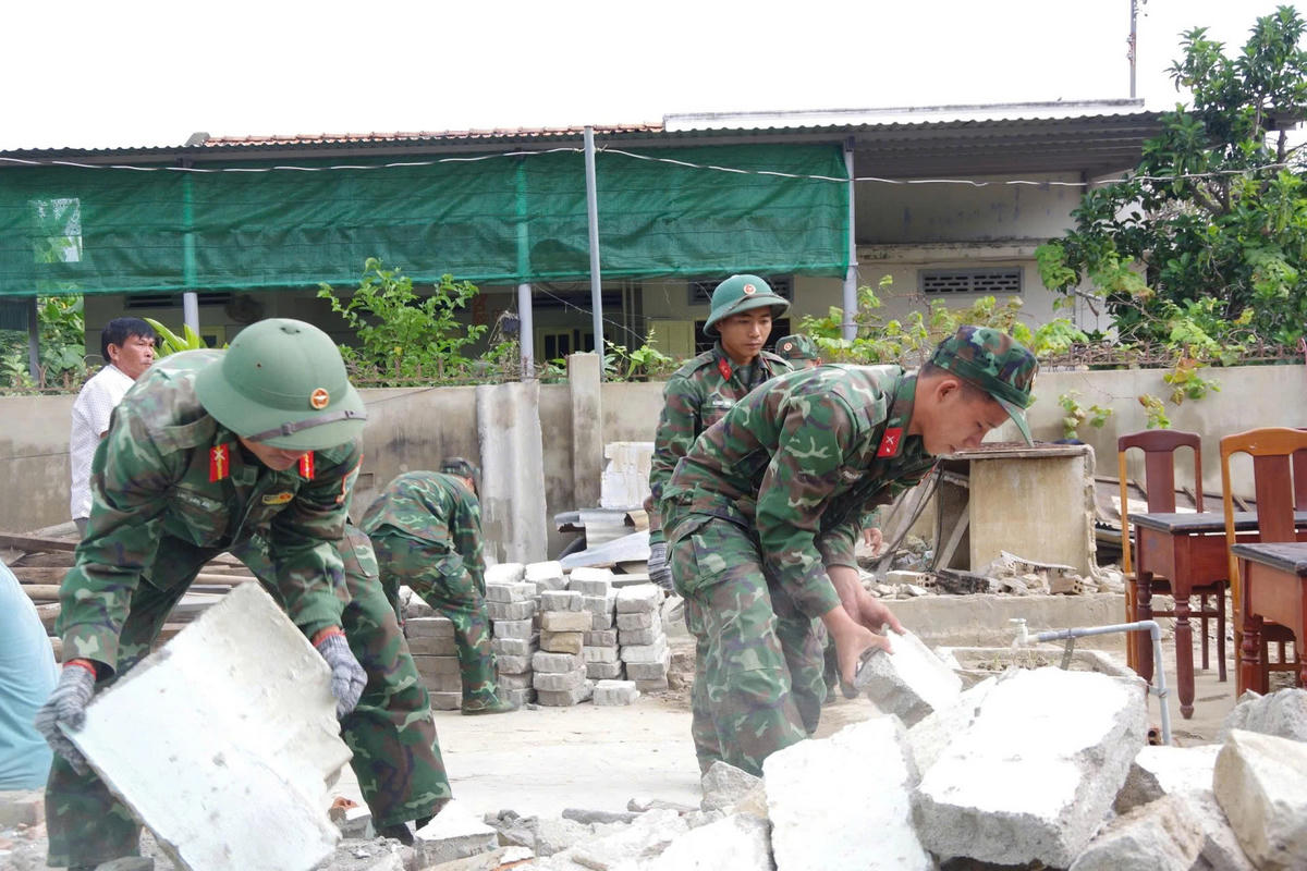 Cán bộ, chiến sĩ Trung đoàn Bộ binh 896 tập trung hỗ trợ xây dựng nhà cho hộ dân bị sập do mưa lũ vừa qua. (ảnh D.T)