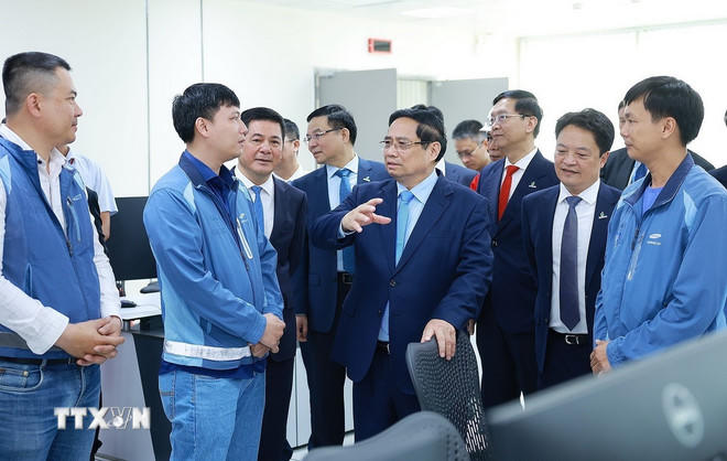 Thủ tướng Phạm Minh Chính với kỹ sư, chuyên gia điều hành Nhà máy điện LNG Nhơn Trạch 3 và 4. (Ảnh: Dương Giang/TTXVN).