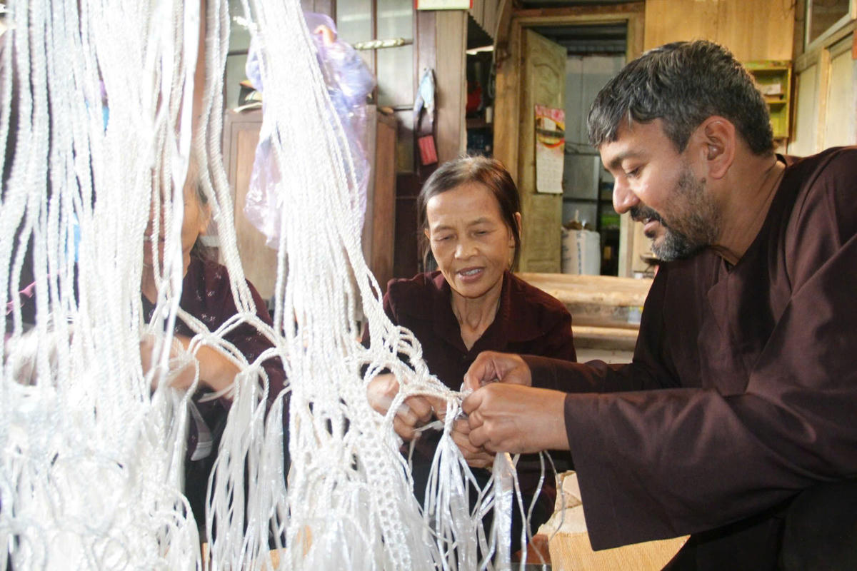 Du khách quốc tế trải nghiệm đan võng ở làng nghề đan võng Giang Biên (Hà Nội). Ảnh: P. Sỹ.