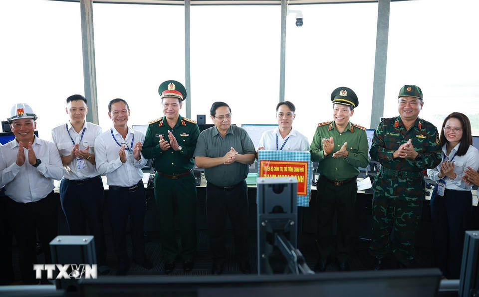 Thủ tướng Phạm Minh Chính tặng quà cho cán bộ, nhân viên cảng hành không quốc tế Long Thành. (Ảnh: Dương Giang/TTXVN).