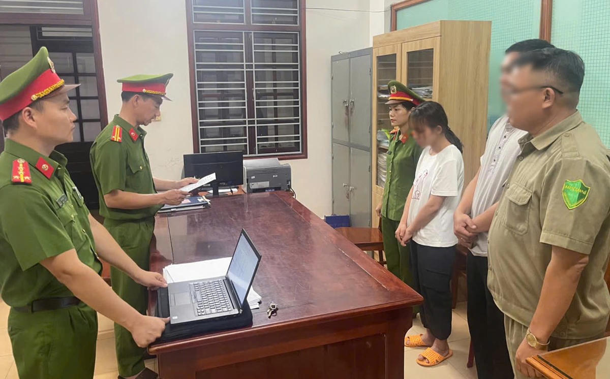 Lực lượng Công an đọc quyết định bắt bà L. Ảnh: CV.