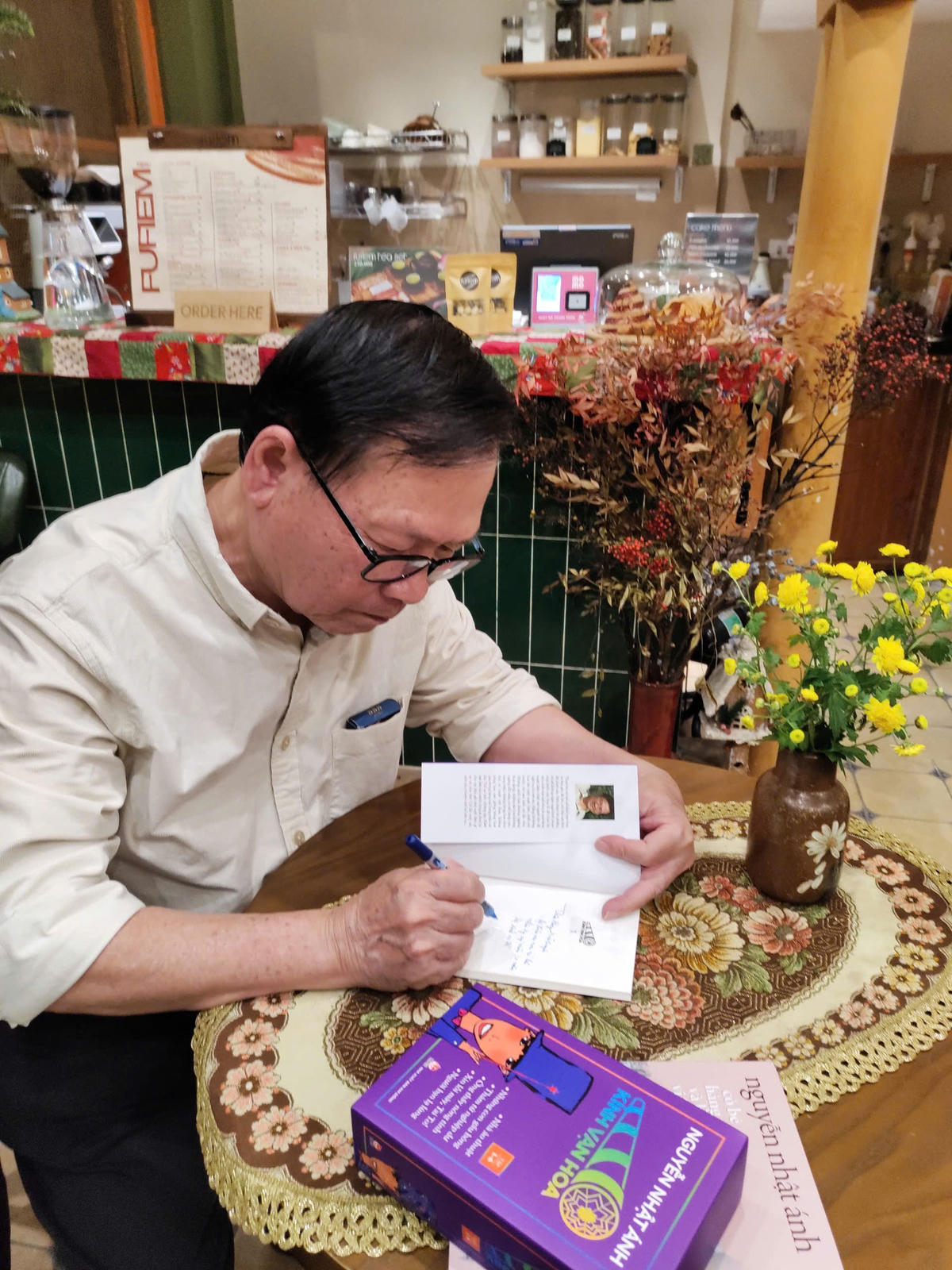 Nhà văn Nguyễn Nhật Ánh tặng chữ ký độc giả nhân ra mắt ấn bản “Kính vạn hoa” trọn bộ 54 tập. Ảnh: P.Hà.