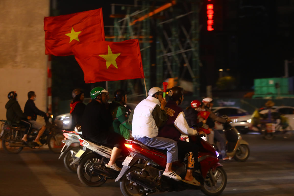 Người dân cầm theo cờ, kèn và các vật cổ vũ đổ ra đường sau khi Việt Nam vô địch.
