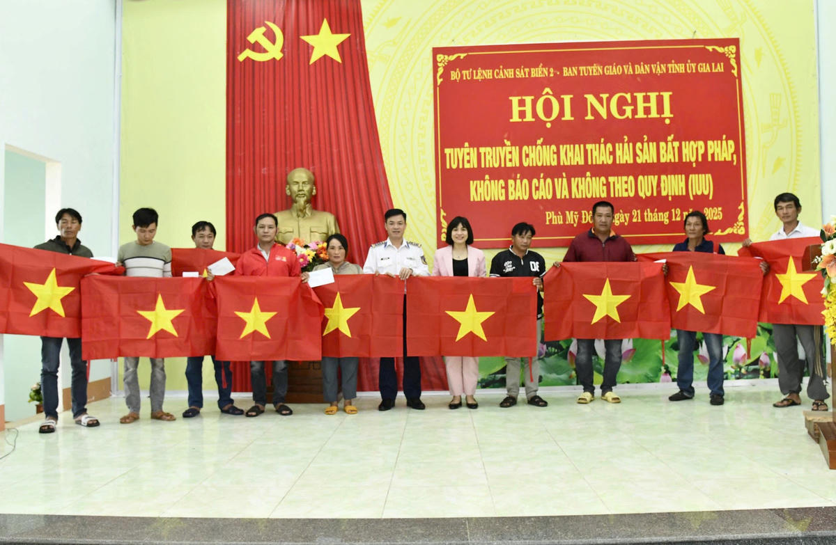 Đại tá Nguyễn Tiến Đức trao quà và cờ Tổ quốc tặng ngư dân xã Phù Mỹ Đông. Ảnh: CV.