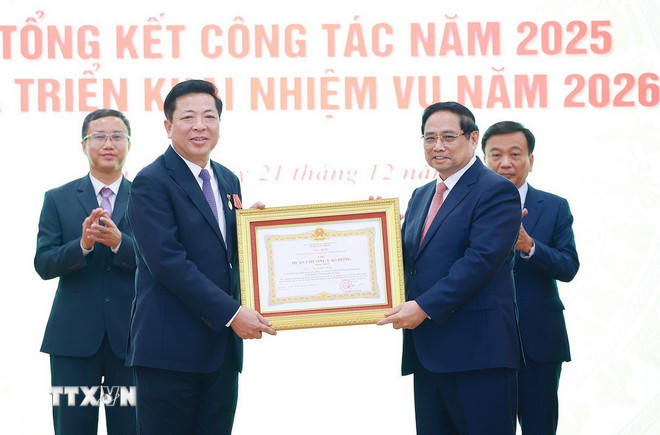 Thủ tướng Phạm Minh Chính trao Huân chương Lao động hạng Nhất cho Bộ trưởng Bộ Xây dựng Trần Hồng Minh. (Ảnh: Dương Giang/TTXVN).