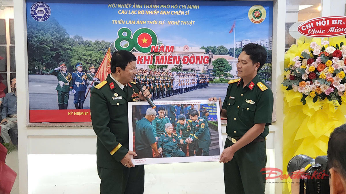 Đại tá, Nghệ sĩ nhiếp ảnh Đoàn Hoài Trung, Chủ tịch Hội Nhiếp ảnh TP Hồ Chí Minh thuyết minh về một bức ảnh xuất sắc tại triển lãm. Ảnh: Hồng Phúc.