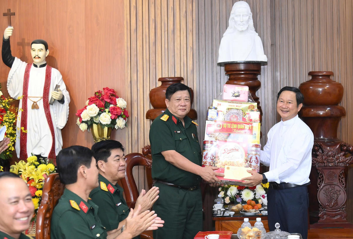 Đại tá Lê Quang Luật, Phó chính ủy Bộ CHQS tỉnh Cà Mau trao quà chúc mừng Lễ Giáng sinh tại Nhà thờ Tắc Sậy. Ảnh: Văn Đông
