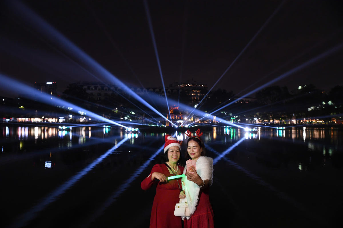 Người dân, du khách ghi lại khoảnh khắc Hồ Gươm lung linh ánh sáng trong những ngày cuối năm 2025. Ảnh: Phạm Sỹ.