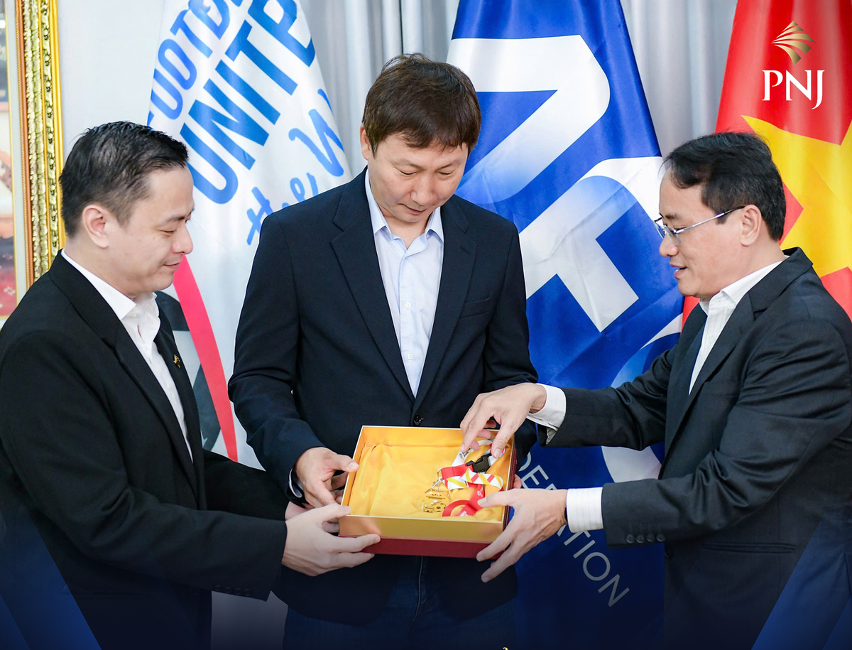 Ông Nguyễn Chí Kiên, Giám đốc cấp cao nguồn nhân lực PNJ (trái) và nhà báo Hoàng Nguyên (Phó Tổng biên tập báo Tuổi Trẻ (phải) trao tấm HCV bằng vàng cho HLV Kim Sang Sik. Ảnh: Nam Trần.