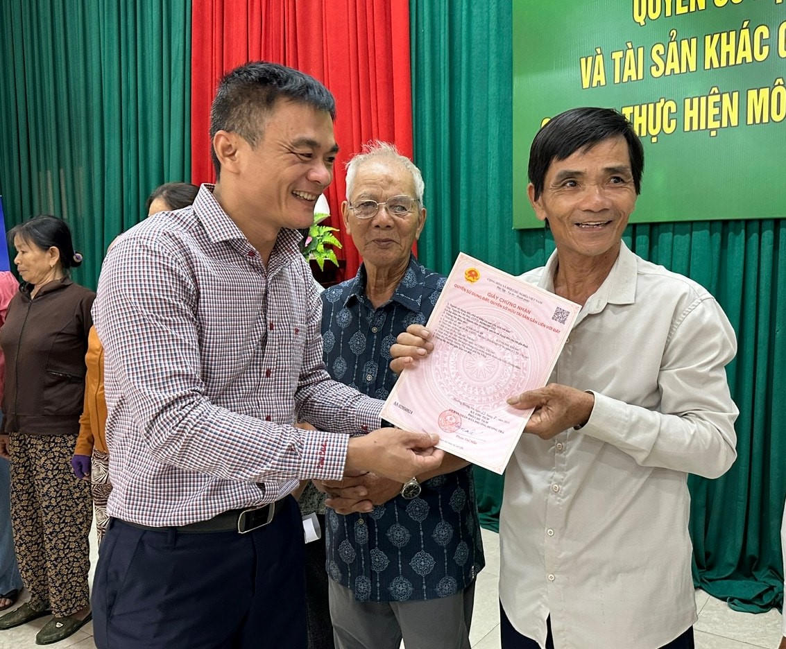 Bí thư Đảng ủy phường Hương Trà Phạm Hoàng Đức trao sổ đỏ cho người dân. Ảnh: CV.