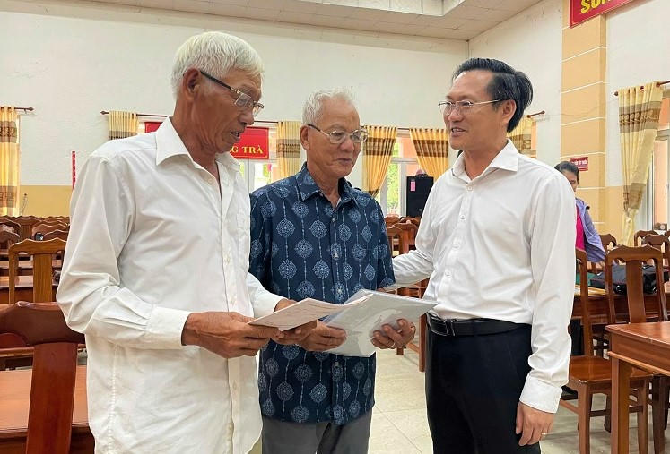 Ông Trần Trung Hậu, Chủ tịch UBND phường Hương Trà (phải) chúc mừng người dân nhận sổ đỏ. Ảnh: CV.