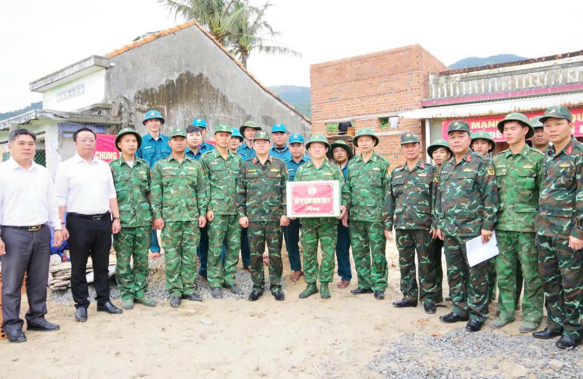 Thiếu tướng Lương Đình Chung tặng quà động viên cán bộ, chiến sĩ xây dựng nhà ở cho người dân. Ảnh: Văn Tân.