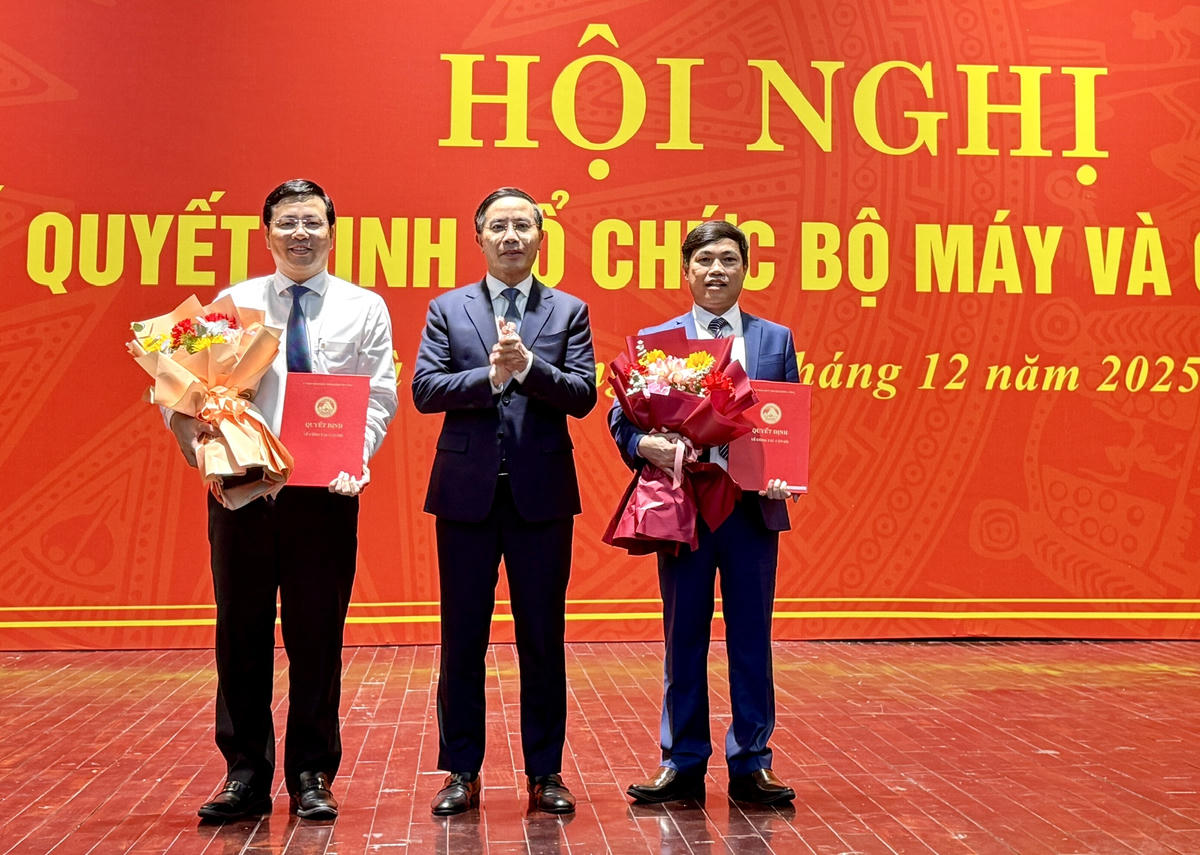 Chủ tịch UBND thành phố Phạm Đức Ấn (giữa) trao hoa và quyết định cho ông Nguyễn Minh Huy (bên trái) và ông Nguyễn Văn Thường. Ảnh: Nguyễn Tú.