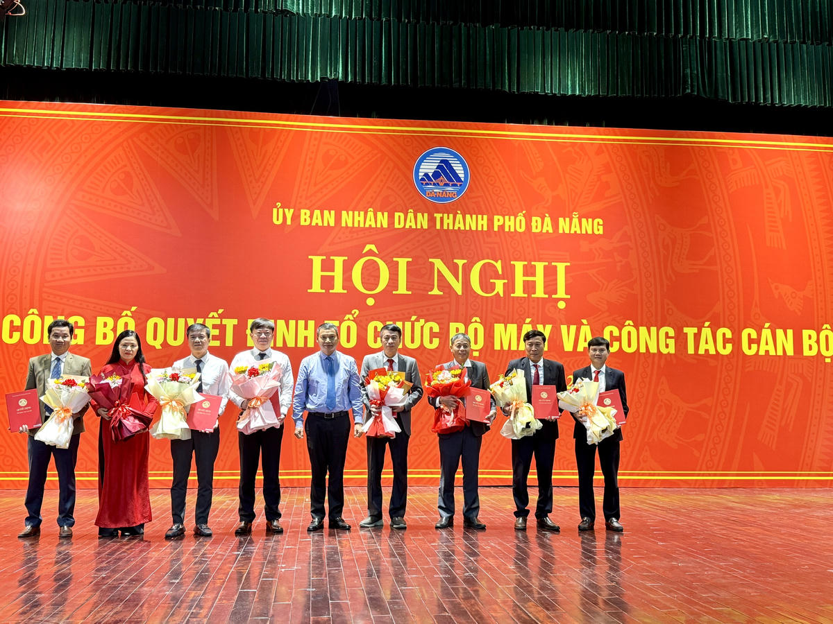 Ông Hồ Kỳ Minh, Phó Chủ tịch Thường trực UBND thành phố trao hoa, quyết định bổ nhiệm, điều động cho 8 phó giám đốc của 2 ban quản lý sau sáp nhập. Ảnh: Nguyễn Tú