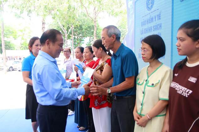Ông Phạm Minh Thành - Giám đốc BHXH tỉnh Đồng Nai trao tặng thẻ BHYT cho người dân có hoàn cảnh khó khăn. Ảnh: Hồ Tú