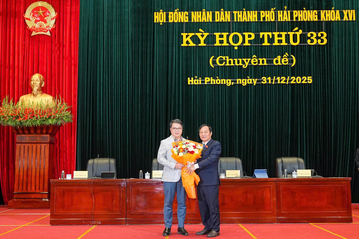 Chủ tịch HĐND thành phố Lê Văn Hiệu tặng hoa chúc mừng ông Nguyễn Thành Hưng, Giám đốc Sở Xây dựng. Ảnh: ĐT. 