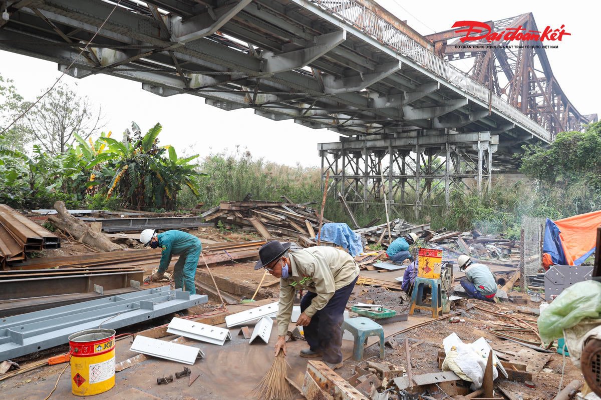 Dưới chân cầu Long Biên, công nhân đang thi công lắp đặt các dầm đỡ chịu lực cho cây cầu.