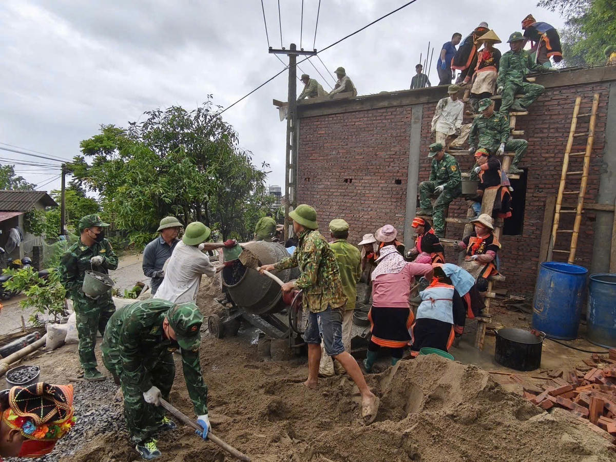 Thực hiện Chương trình Xoá nhà tạm, nhà dột nát, cán bộ chiến sĩ Đồn biên phòng cửa khẩu Ma Lù Thàng, BĐBP Lai Châu cùng bà con đồng bào dân tộc Dao đỏ ở bản Hùng Pèng, xã Phong Thổ xây nhà mới cho người nghèo. Ảnh: Ngô Hùng. 