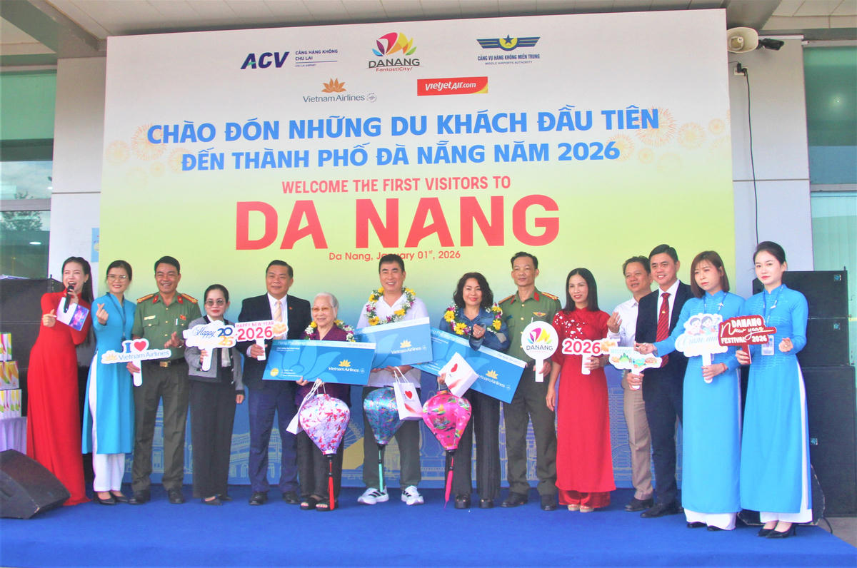 Lãnh đạo TP Đà Nẵng cùng các hành khách đầu tiên năm 2026 đến sân bay Chu Lai chụp ảnh lưu niệm. Ảnh: Tấn Thành.