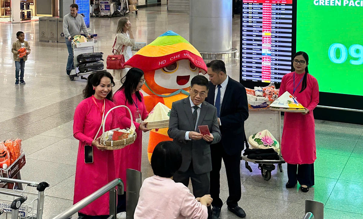 Ông Nguyễn Văn Dũng - Phó Chủ tịch UBND TP Hồ Chí Minh tặng hoa và quà cho những vị khách đầu tiên "xông đất" thành phố đầu năm mới. Ảnh: H.T