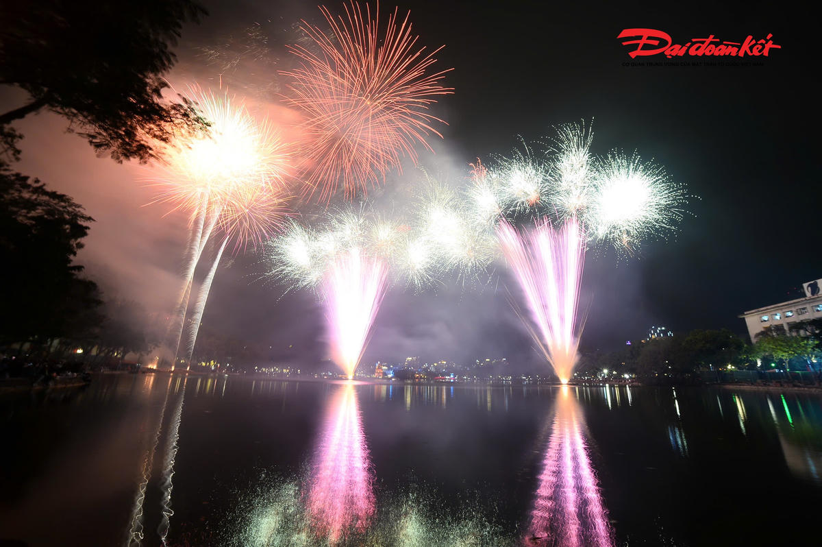 Pháo hoa tỏa ra thành từng lớp, từng tầng ánh sáng, đan xen sắc vàng óng, đỏ thắm, xanh biếc và tím hồng, tạo nên một bức tranh sống động giữa nền trời đêm.. 