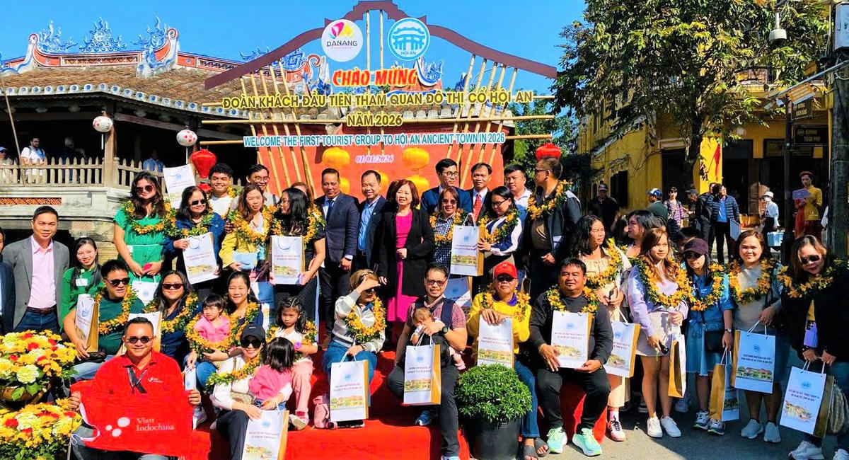 Lãnh đạo TP Đà Nẵng cùng đoàn khách quốc tế đầu tiên đến phố cổ Hội An&nbsp; đầu năm mới 2026 chụp ảnh lưu niệm. Ảnh: Tấn Thành.