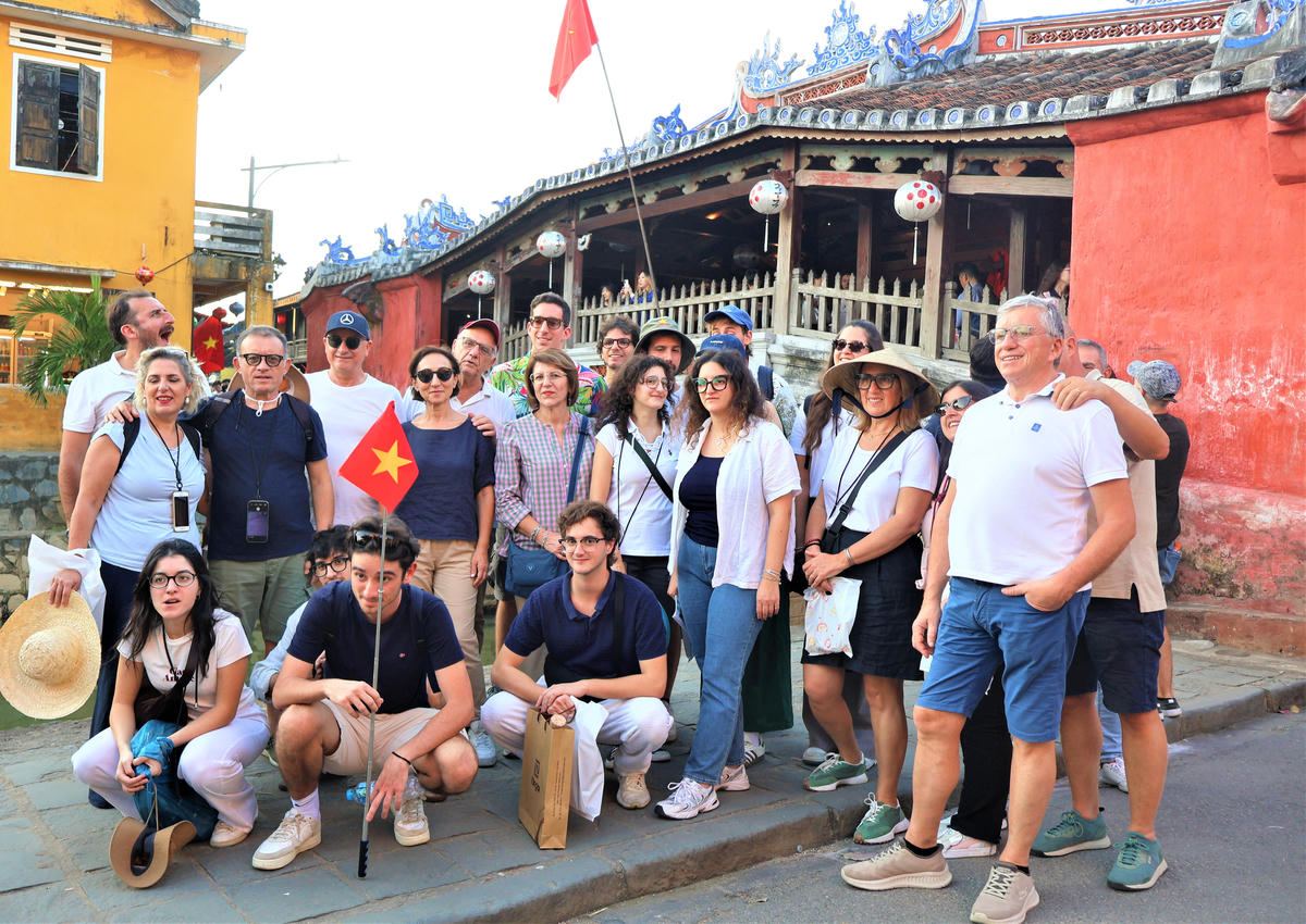 Đoàn du khách chụp ảnh lưu niệm bên chùa Cầu Hội An. Ảnh: Chí Đại.