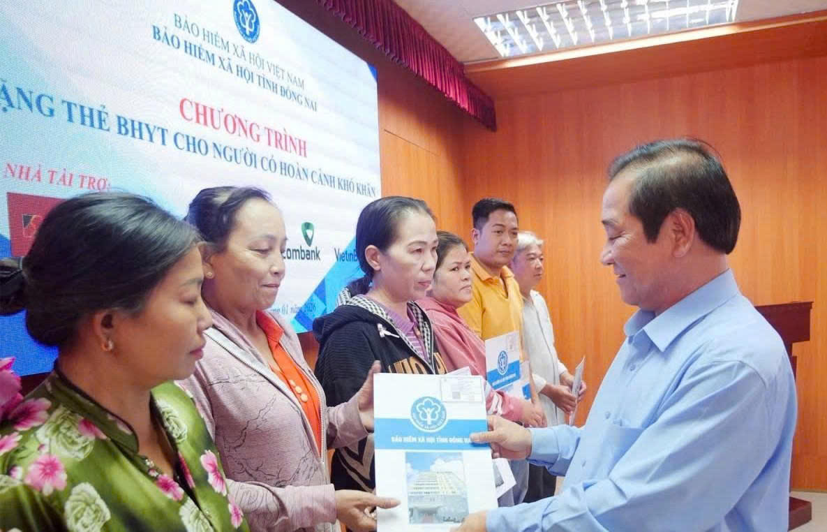 Ông Phạm Minh Thành - Giám đốc BHXH tỉnh Đồng Nai trao tặng thẻ BHYT cho người dân có hoàn cảnh khó khăn. Ảnh: Hồ Tú