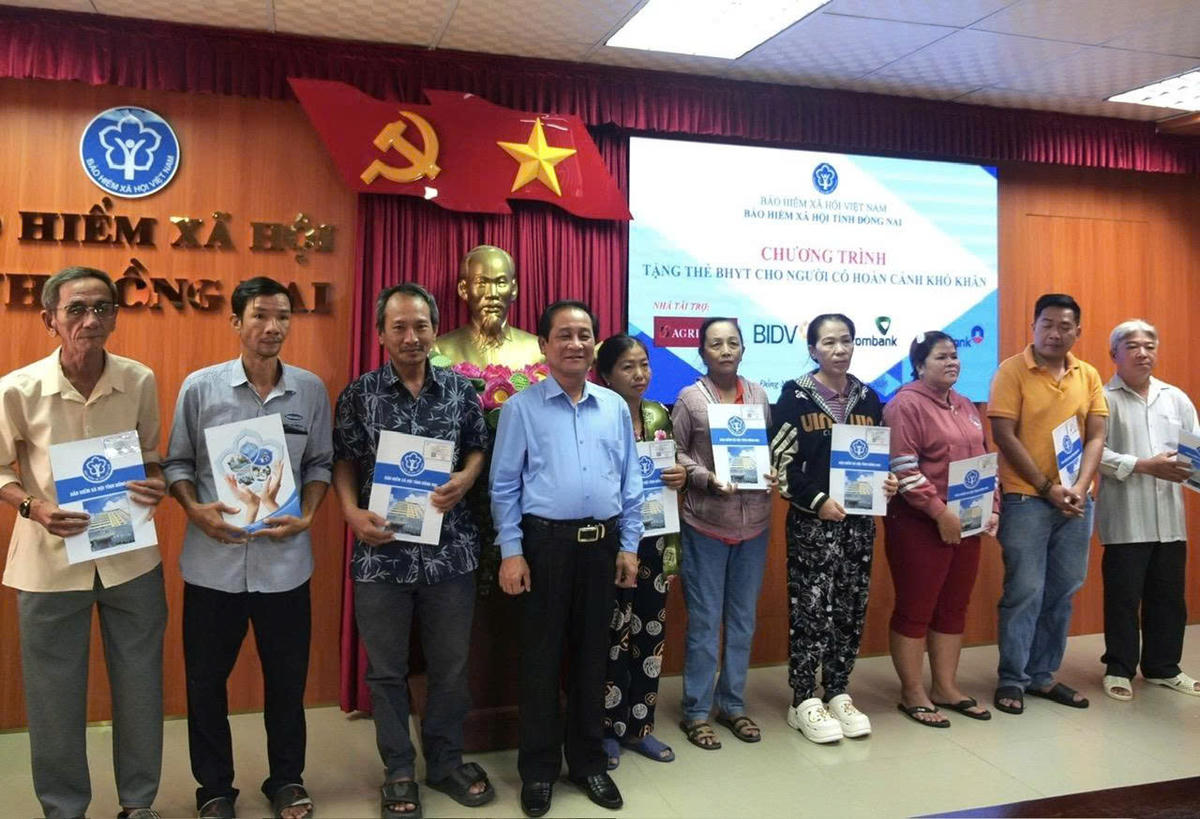 Trao tặng thẻ BHYT, sổ BHXH cho người có hoàn cảnh khó khăn. Ảnh: Hồ Tú