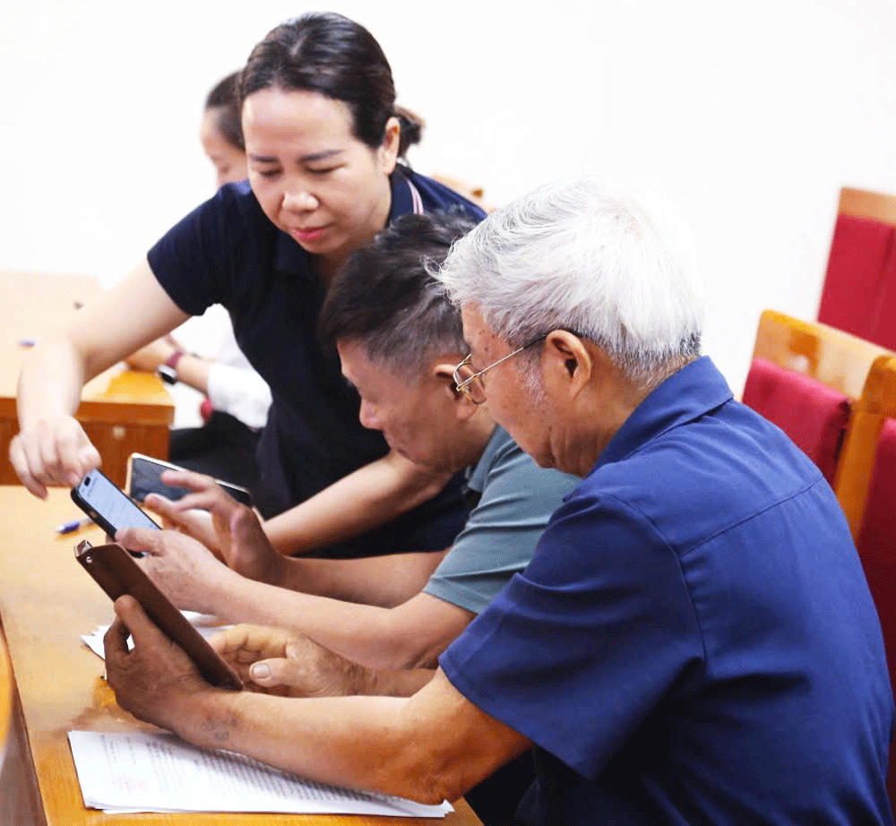 Đại diện Ủy ban MTTQ Việt Nam phường Dương Nội (Hà Nội) hướng dẫn triển khai nền tảng “Mặt trận số” cho các thành viên Ban Công tác Mặt trận. 	Ảnh: Bích Hời
