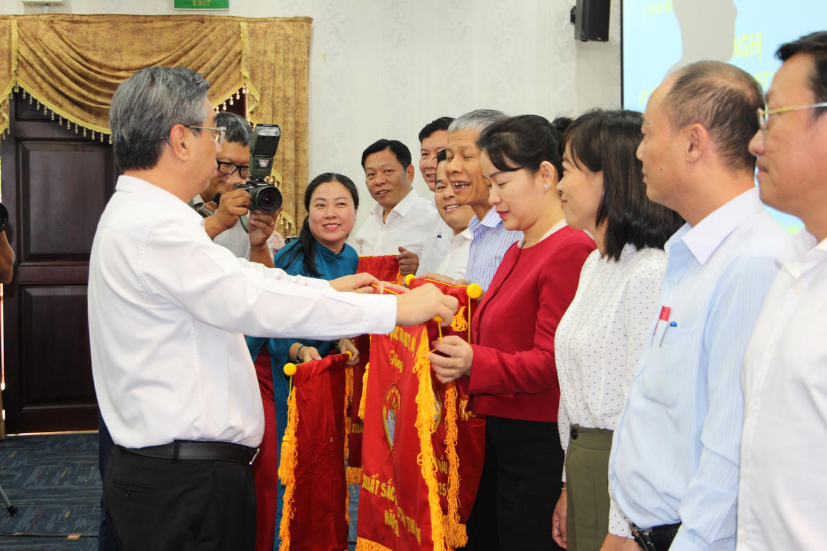 Ông Nguyễn Phước Lộc – Phó Bí thư Thành uỷ, Chủ tịch Uỷ ban Mặt trận Tổ quốc Việt Nam TP Hồ Chí Minh trao Cờ thi đua cho các đơn vị xuất sắc trong công tác Mặt trận. Ảnh: Q.Đ.