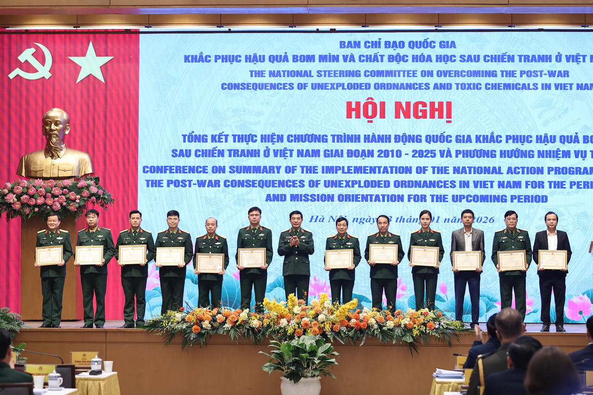Bộ trưởng Bộ Quốc phòng Phan Văn Giang trao bằng khen của Bộ trưởng Bộ Quốc phòng cho các tập thể, cá nhân có thành tích xuất sắc trong công tác khắc phục hậu quả bom mìn. Ảnh: Nhật Bắc